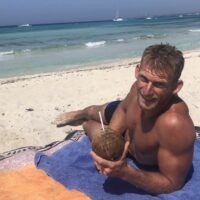 Luke en la playa con un coco